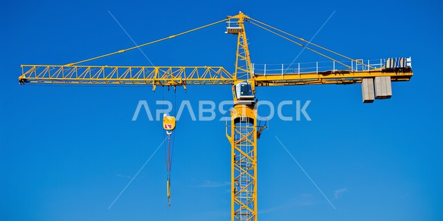 Construction works, concrete pouring and foundation laying, heavy machinery and equipment, cranes and high scaffolding, building under construction in Saudi Arabia, concept of structural and architectural engineering, implementation of construction plan and formation of metal structure