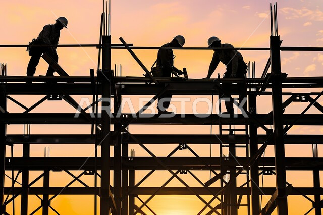 صورة ظلية لمبنى قيد الانشاء في المملكة العربية السعودية، مفهوم الهندسة الانشائية والمعمارية، مجموعة من العمال يقومون بتنفيذ مخطط الإعمار وتشكيل الهيكل المعدني، اعمال البناء وصب الخرسانات ووضع الأساسات، الآلات والمعدات الثقيلة والرافعات والسقالات العالية, سالوييت