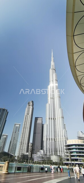 الفن الهندسي المعماري في بناء المنشآت والمباني السكنية في مدينة دبي، جذب واستقطاب السياح من جميع أنحاء العالم، ناطحات السحاب والأبراج في الامارات العربية المتحدة، معلم سياحي مشهور، صورة من الأسفل لمبنى برج خليفة الشهير بجانب نافورة دبي مول