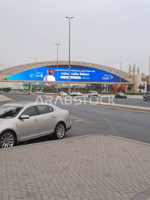 حركة مرور السيارات في الطرقات والشوارع المعبدة، جسر المشاة فوق شارع الاندلس في مدينة جدة في المملكة العربية السعودية، اعمدة الانارة على اطراف الطريق الاسفلتي العام، الاهتمام بالبنية التحتية