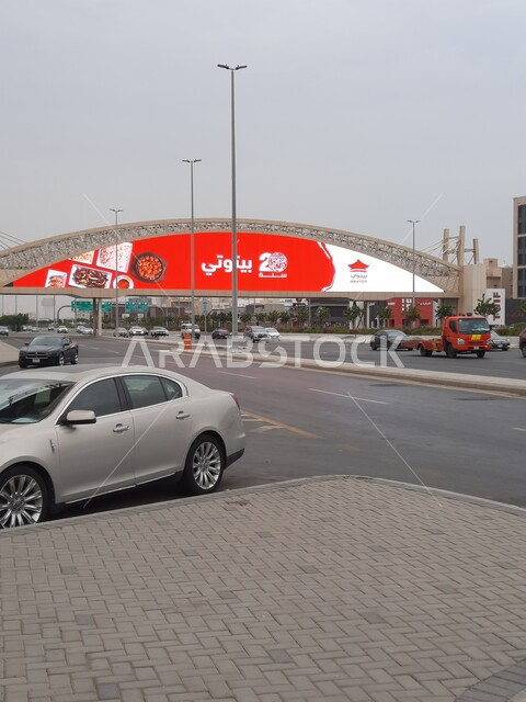 حركة مرور السيارات في الطرقات والشوارع المعبدة، جسر المشاة فوق شارع الاندلس في مدينة جدة في المملكة العربية السعودية، اعمدة الانارة على اطراف الطريق الاسفلتي العام، الاهتمام بالبنية التحتية