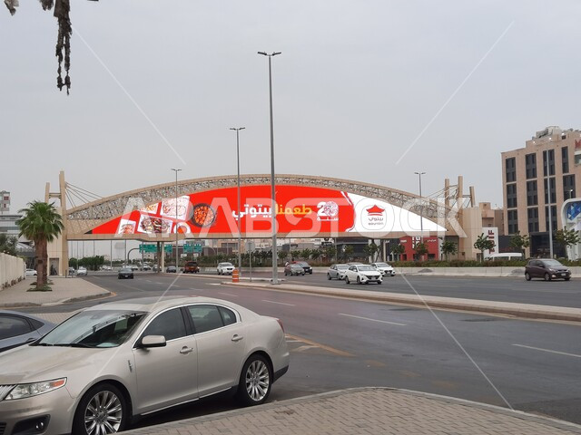 حركة مرور السيارات في الطرقات والشوارع المعبدة، جسر المشاة فوق شارع الاندلس في مدينة جدة في المملكة العربية السعودية، اعمدة الانارة على اطراف الطريق الاسفلتي العام، الاهتمام بالبنية التحتية