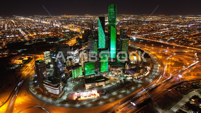 صورة جوية لمركز الملك عبدالله المالي (كافد) في الرياض بالمملكة العربية السعودية ،صورة للأبراج مالية واقتصادية والمنشأت المعمارية ليلاً مضيئة باللون الأخضر ،السياحة في السعودية ، إطلالة رائعة على مركز الملك عبدالله المالي بالرياض