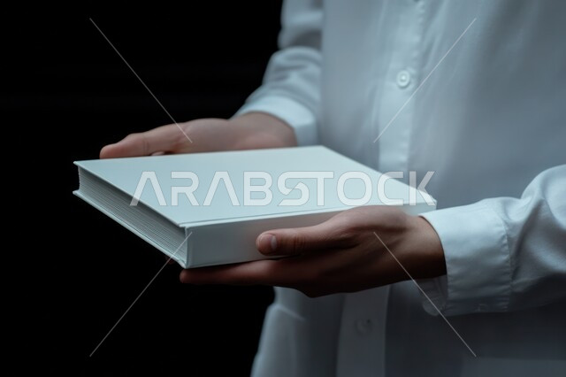 طالب جامعي عربي خليجي سعودي يرتدي الزي الخليجي التقليدي ،يقضي وقت ممتع في مكتبة الجامعة ،قراءة كتاب داخل المكتبة، تدوين الملاحظات ،استعارة كتاب مناسب ، اثراء التعليم الجامعي ، البحث العلمي في المكاتب ، مفهوم التعليم والتعلم