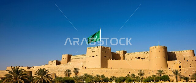 الهندسة المعمارية والمباني الطينية القديمة من التراث السعودي، أماكن ومعالم أثرية سياحية في السعودية، سارية العلم الوطني السعودي يرفرف بالسماء،  صورة مقربة لقصر المصمك التاريخي في مدينة الرياض في المملكة العربية السعودية