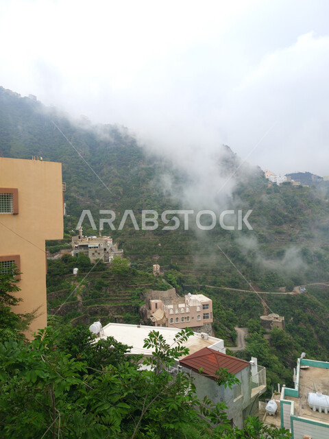 الاستمتاع بالمناظر الطبيعية والأشجار والنباتات الخضراء في المملكة العربية السعودية، الغيوم والأجواء الضبابية فوق القمم والمرتفعات الجبلية في محافظة فيفاء،  المباني السكنية والبيوت على سفوح الجبال