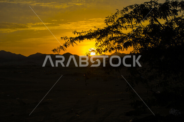 صورة جمالية خلابة لغروب وشروق الشمس , غروب وشروق الشمس الإبداعي من الصحراء, جمال الطبيعة الصحراوية الخلابة في وقت غروب وشروق الشمس ، صورة ظلية للجبال والطبيعة الخلابة ، منظر رائع وخلاب في سماء السعودية