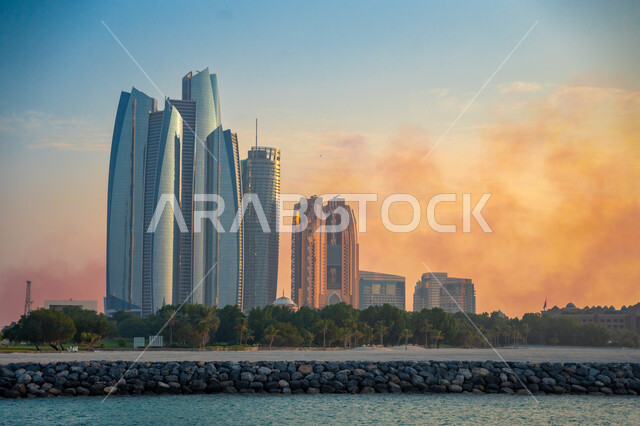 التطور العمراني للبناء في ابو ظبي، منظر للأبراج العالية وناطحات السحاب الشامخة في وقت الغروب، الفن الهندسي المعماري في تصميم الفنادق والعمارات
