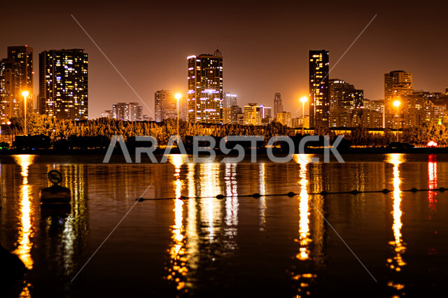  وجهات جذب واستقطاب السياح، الفن الهندسي المعماري في بناء الأبراج وناطحات السحاب على شاطئ الممزر, الواجهة البحرية الساحلية في مدينة دبي, انعكاس الأضواء والأنوار للفنادق والمباني على مياه البحر في وقت الليل، النمو والتطور العمراني في الامارات العربية المتحدة