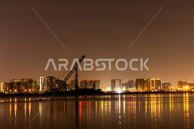  وجهات جذب واستقطاب السياح، الفن الهندسي المعماري في بناء الأبراج وناطحات السحاب على شاطئ الممزر, الواجهة البحرية الساحلية في مدينة دبي, انعكاس الأضواء والأنوار للفنادق والمباني على مياه البحر في وقت الليل، النمو والتطور العمراني في الامارات العربية المتحدة