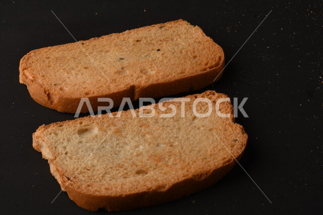 مجموعة من نباتات القمح ، شرائح خبز التوست المحمصة على خلفية سوداء