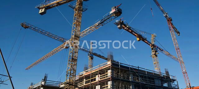 رافعات البناء تعمل على بناء منشآة جديدة في المملكة العربية السعودية, مفهوم تطوير البنية التحتية, تنفيذ مخطط الإعمار  وتشكيل الهيكل المعدني, الالات والمعدات الثقيلة والرافعات والسقالات العالية, أعمال البناء وصب الخرسانات