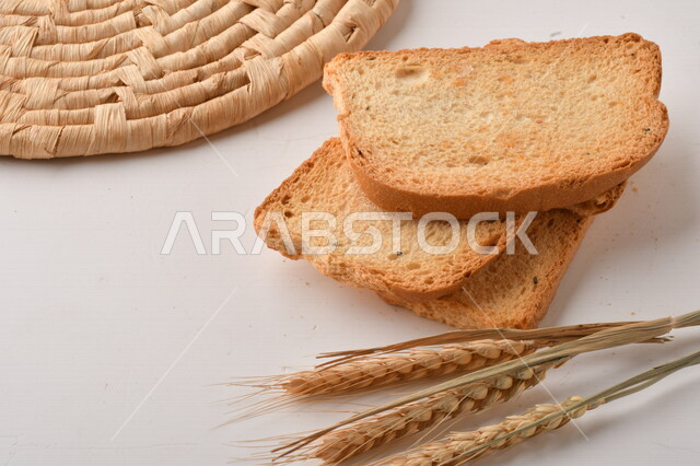 مجموعة من نباتات القمح ، صورة مقربة لشرائح خبز التوست المحمصة على خلفية بيضاء