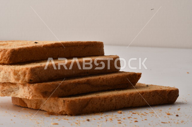 مجموعة من نباتات القمح ، صورة مقربة لشرائح خبز التوست المحمصة على خلفية بيضاء