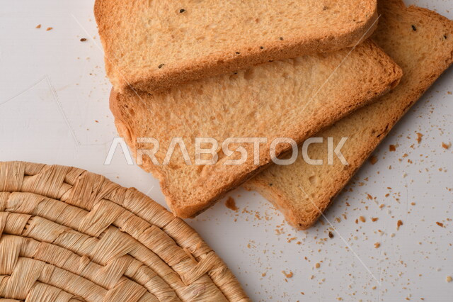 مجموعة من نباتات القمح ، صورة مقربة لشرائح خبز التوست المحمصة على خلفية بيضاء