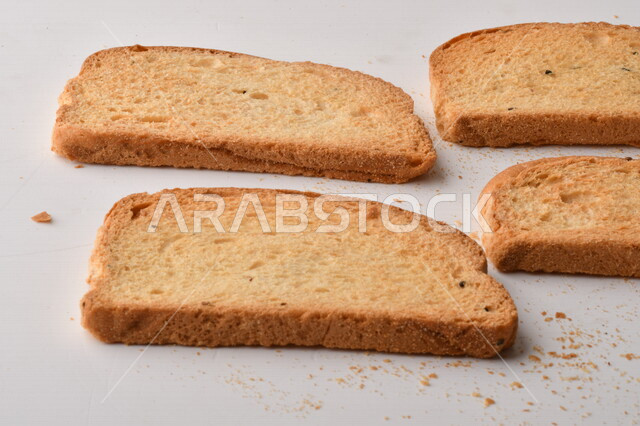 مجموعة من نباتات القمح ، صورة مقربة لشرائح خبز التوست المحمصة على خلفية بيضاء