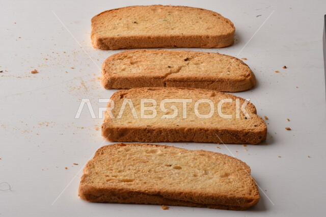 مجموعة من نباتات القمح ، صورة مقربة لشرائح خبز التوست المحمصة على خلفية بيضاء