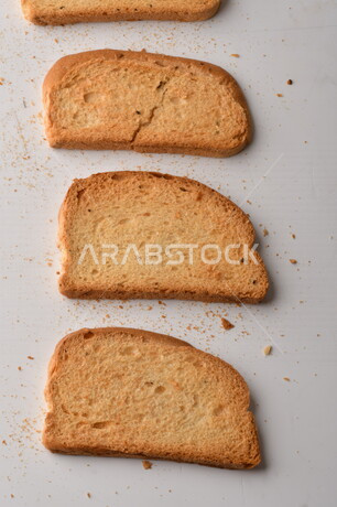مجموعة من نباتات القمح ، صورة مقربة لشرائح خبز التوست المحمصة على خلفية بيضاء