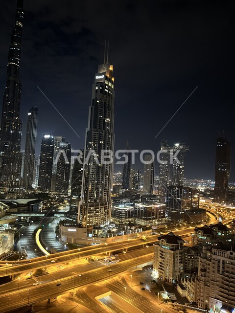 Architectural engineering art of towers and skyscrapers, famous tourist attractions in the United Arab Emirates, work on the development and improvement of towers and buildings, streets in front of Burj Khalifa at night in the Emirate of Dubai