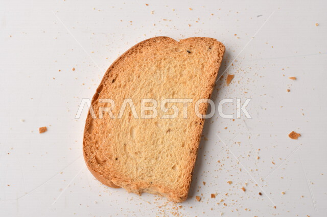 Group of wheat plants, close-up of toasted slices of bread on white background