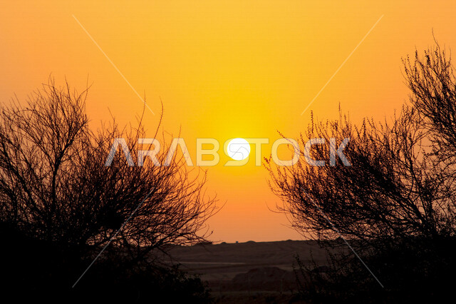 صورة جمالية خلابة لغروب وشروق الشمس البرتقالي , غروب وشروق الشمس الإبداعي من الصحراء, جمال الطبيعة الصحراوية الخلابة في وقت غروب وشروق الشمس ، صورة ظلية للجبال والطبيعة الخلابة ، منظر رائع وخلاب في سماء السعودية