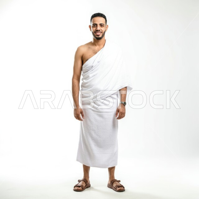النظر إلى الكاميرا بإيماءات السرور، أداء مناسك الحج والعمرة، بورتريه لرجل عربي سعودي خليجي مبتسم يرتدي ملابس الاحرام، الجسم بالطول الكامل، مفهوم العبادة والتقرب إلى الله، خلفية بيضاء
