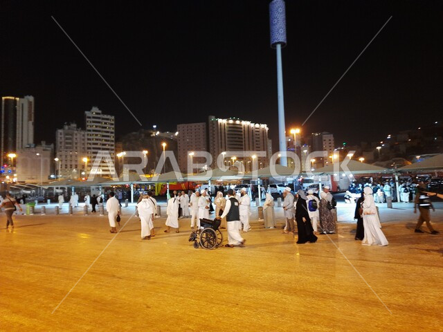 تجمع زوار بيت الله الحرام في الفناء الخارجي للمسجد الحرام, قدوم المسلمين من جميع أنحاء العالم إلى الاماكن الدينية المقدسة, المعالم الاسلامية المشهورة في المملكة العربية السعودية, شوارع وطرقات مكة المكرمة المضيئة ليلا