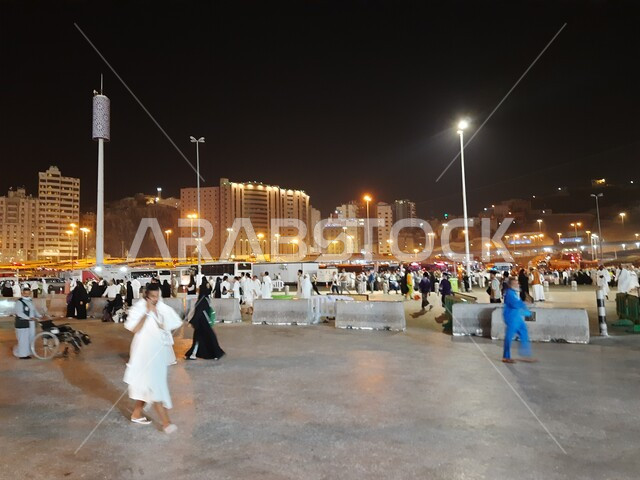 Visitors to the House of God gather in the outer courtyard of the Grand Mosque, Muslims from all over the world come to the holy religious places, famous Islamic landmarks in the Kingdom of Saudi Arabia, streets and roads of Mecca illuminated at night