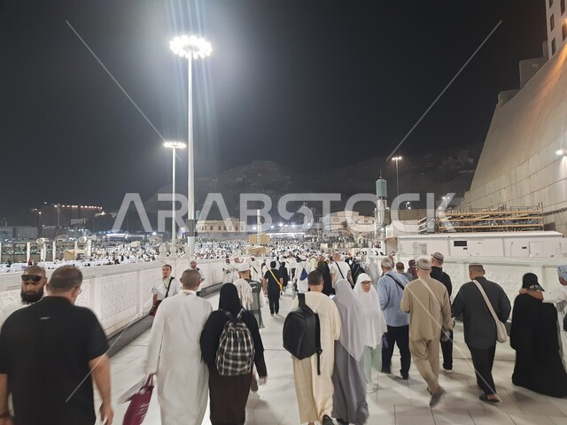 تجمع زوار بيت الله الحرام في الفناء الخارجي للمسجد الحرام, قدوم المسلمين من جميع أنحاء العالم إلى الاماكن الدينية المقدسة, المعالم الاسلامية المشهورة في المملكة العربية السعودية, شوارع وطرقات مكة المكرمة المضيئة ليلا