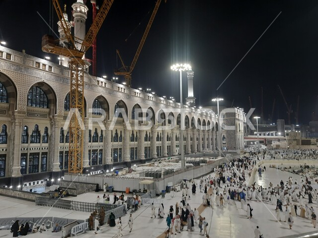 آداء مناسك الحج والعمرة، المعالم الاسلامية المشهورة في المملكة العربية السعودية، قدوم المسلمين من جميع أنحاء العالم إلى الاماكن الدينية المقدسة, تجمع زوار بيت الله الحرام في الفناء الخارجي للمسجد الحرام المضيء ليلا في مكة المكرمة