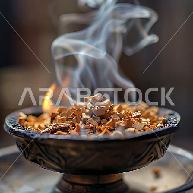 منتج وطني محلي سعودي، خشب العود الفاخر والفحم، منظر الدخان المنتشر من البخور، أصالة العادات والتقاليد في المملكة العربية السعودية، التعطر والتطيب باطيب الروائح والعطور، مبخرة معدنية في مكان تراثي