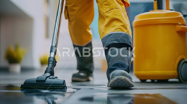 المهام والأعمال المنزلية الروتينية, القيام بتنظيف المنزل باستخدام المكنسة, أدوات التنظيف الكهربائية, لقطة مقربة لعامل يرتدي زي العمل
