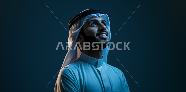 مفهوم التأمل والتخطيط للمستقبل, التركيز والنظر إلى شيء ما, بورتريه مقرب لشاب عربي خليجي سعودي يرتدي الثوب التقليدي والغترة يقف بإيماءات السرور, خلفية كحلية