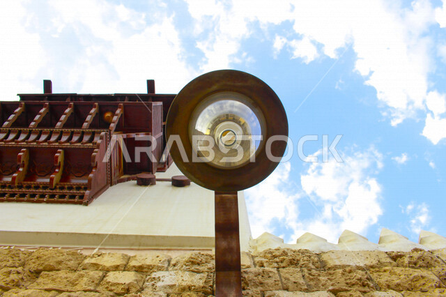 ضوء الشارع المعدني الأسود تحت السماء الزرقاء في المملكة العربية السعودية ,منظر زاوية منخفضة للمصباح الكهربائي, ضوء الشارع منير ,عمود مصباح الشارع ,الصورة المقربة ,معالم تاريخية أثرية في جدة