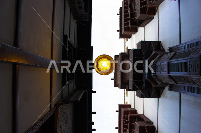 ضوء الشارع المعدني الأسود تحت السماء الزرقاء في المملكة العربية السعودية ,منظر زاوية منخفضة للمصباح الكهربائي, ضوء الشارع منير ,عمود مصباح الشارع ,الصورة المقربة ,معالم تاريخية أثرية في جدة