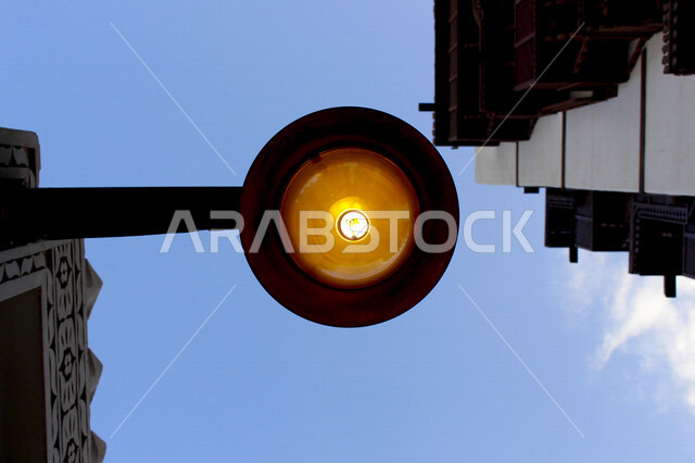 ضوء الشارع المعدني الأسود تحت السماء الزرقاء في المملكة العربية السعودية ,منظر زاوية منخفضة للمصباح الكهربائي, ضوء الشارع منير ,عمود مصباح الشارع ,الصورة المقربة ,معالم تاريخية أثرية في جدة