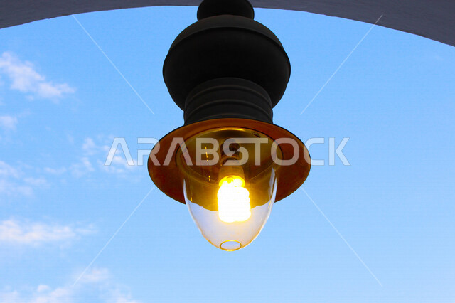 ضوء الشارع المعدني الأسود تحت السماء الزرقاء في المملكة العربية السعودية ,منظر زاوية منخفضة للمصباح الكهربائي, ضوء الشارع منير ,عمود مصباح الشارع ,الصورة المقربة ,معالم تاريخية أثرية في جدة