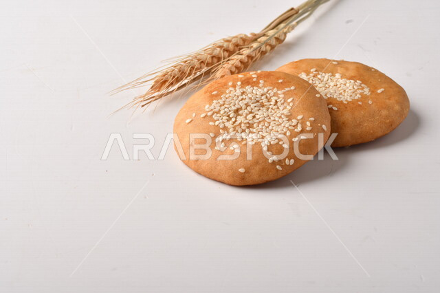 مجموعة من نباتات القمح ، صورة مقربة لبسكويت القمح الهشة والمقرمشة على خلفية بيضاء