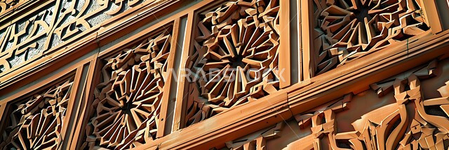 النقوش والزخارف الحرفية المتميزة على الطراز الإسلامي، الفن الهندسي المعماري القديم للأبواب والنوافذ الخشبية الأثرية، صورة بانورامية للأنماط الهندسية المعقدة على واجهة مبنى تاريخي في المملكة العربية السعودية