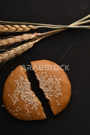 صورة مقربة لمجموعة من نباتات القمح ، وبسكويت القمح الهشة والمقرمشة على خلفية سوداء