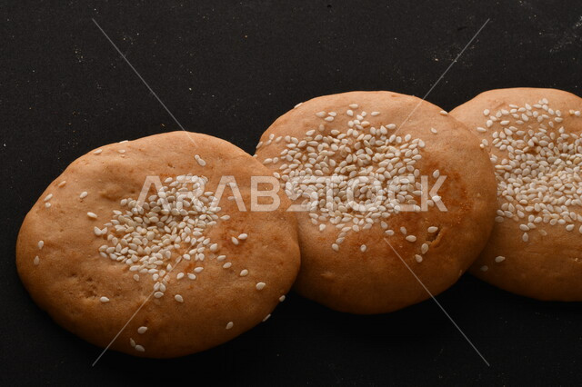 صورة مقربة لمجموعة من نباتات القمح ، وبسكويت القمح الهشة والمقرمشة على خلفية سوداء