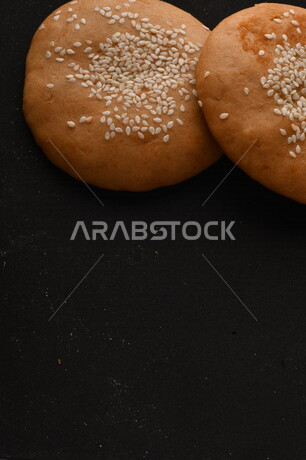 صورة مقربة لمجموعة من نباتات القمح ، وبسكويت القمح الهشة والمقرمشة على خلفية سوداء