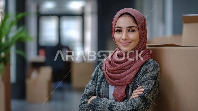 مفهوم الأنوثة والاهتمام بالمظهر الخارجي، صورة مقربة لامرأة عربية خليجية سعودية محجبة تنظر الى الكاميرا بايماءات وجه سعيدة، الوقوف باستقامة وثقة مع ايدي متقاطعة، صورة شخصية للوثائق الرسمية، أزياء محجبات عصرية وأنيقة، الملامح العربية القوية