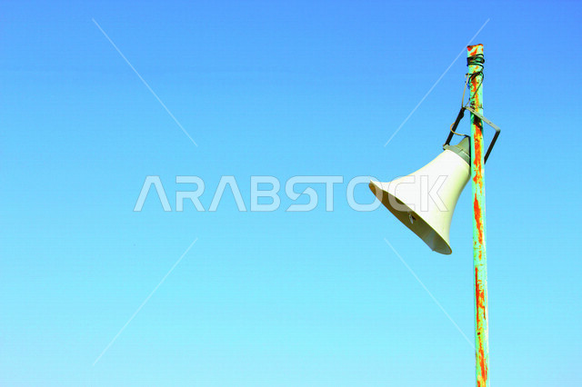 مكبر الصوت معلق على عمود في أحد المساجد ، مكبر صوت لوقت الأذان للصلاة ، دعوة المسملين للصلاة ، مايكرفون لمناداة الناس