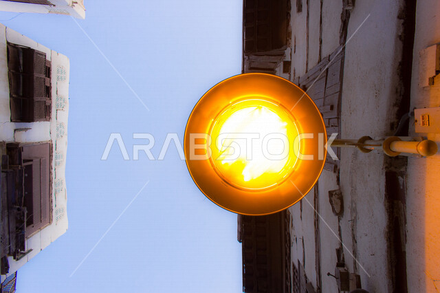 ضوء الشارع المعدني الأسود تحت السماء الزرقاء في المملكة العربية السعودية , منظر زاوية منخفضة للمصباح الكهربائي , ضوء الشارع منير , عمود مصباح الشارع , الصورة المقربة , معالم تاريخية أثرية