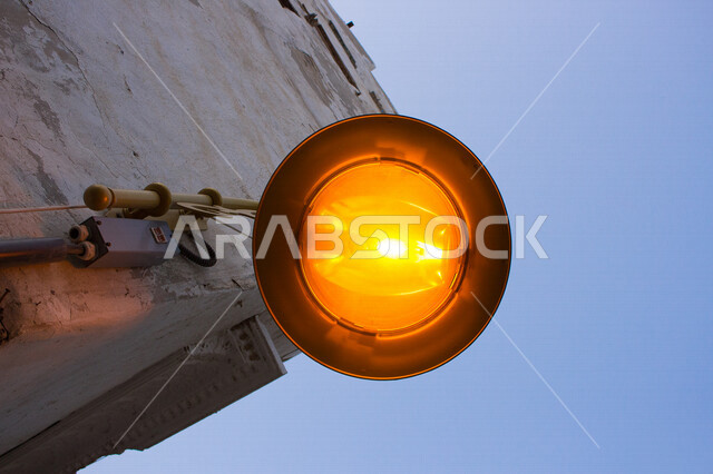 ضوء الشارع المعدني الأسود تحت السماء الزرقاء في المملكة العربية السعودية , منظر زاوية منخفضة للمصباح الكهربائي , ضوء الشارع منير , عمود مصباح الشارع , الصورة المقربة , معالم تاريخية أثرية