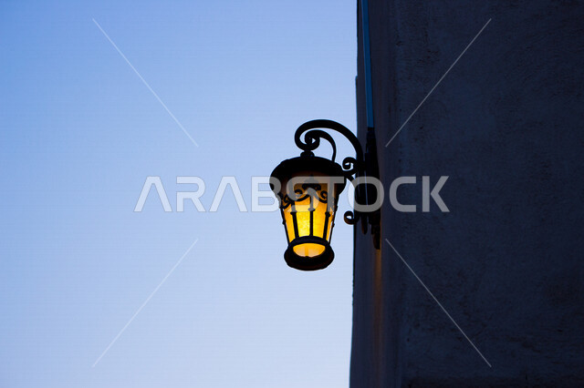 ضوء الشارع المعدني الأسود تحت السماء الزرقاء في المملكة العربية السعودية , منظر زاوية منخفضة للمصباح الكهربائي , ضوء الشارع منير , عمود مصباح الشارع , الصورة المقربة , معالم تاريخية أثرية