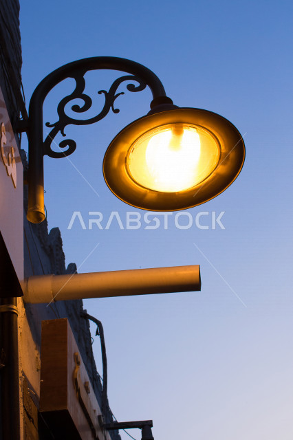 ضوء الشارع المعدني الأسود تحت السماء الزرقاء في المملكة العربية السعودية , منظر زاوية منخفضة للمصباح الكهربائي , ضوء الشارع منير , عمود مصباح الشارع , الصورة المقربة , معالم تاريخية أثرية