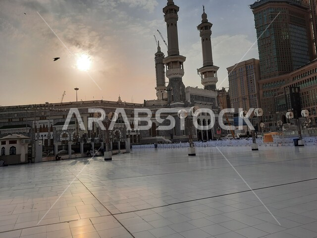 الفناء الخارجي للمسجد الحرام في وقت الغروب، الفن الهندسي المعماري في بناء المآذن الشامخة على الطراز الإسلامي، ساحات الحرم المكي الشريف الخارجية في مكة المكرمة بالمملكة العربية السعودية، أداء مناسك الحج والعمرة، معالم دينية إسلامية مقدسة، أماكن العبادة والطاعة