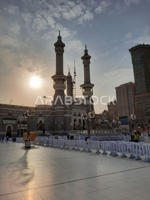 الفناء الخارجي للمسجد الحرام في وقت الغروب، الفن الهندسي المعماري في بناء المآذن الشامخة على الطراز الإسلامي، ساحات الحرم المكي الشريف الخارجية في مكة المكرمة بالمملكة العربية السعودية، أداء مناسك الحج والعمرة، معالم دينية إسلامية مقدسة، أماكن العبادة والطاعة